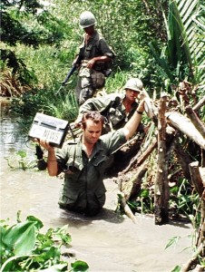 Don North of ABC News crossing stream in Mekong Delta with US Army 9th Division.